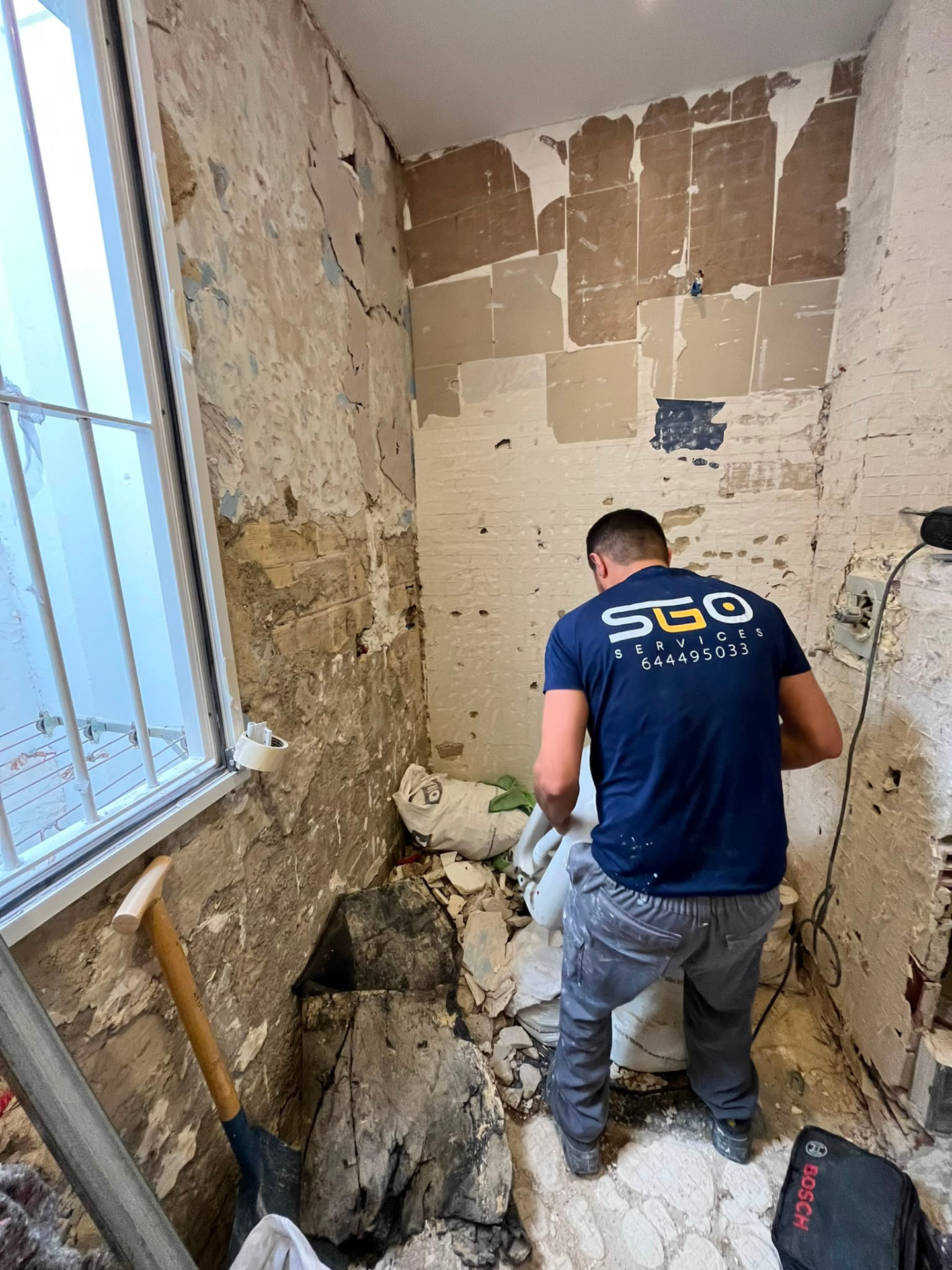 Operario de SGO Services desmontando sanitarios en una reforma de baño en Valencia