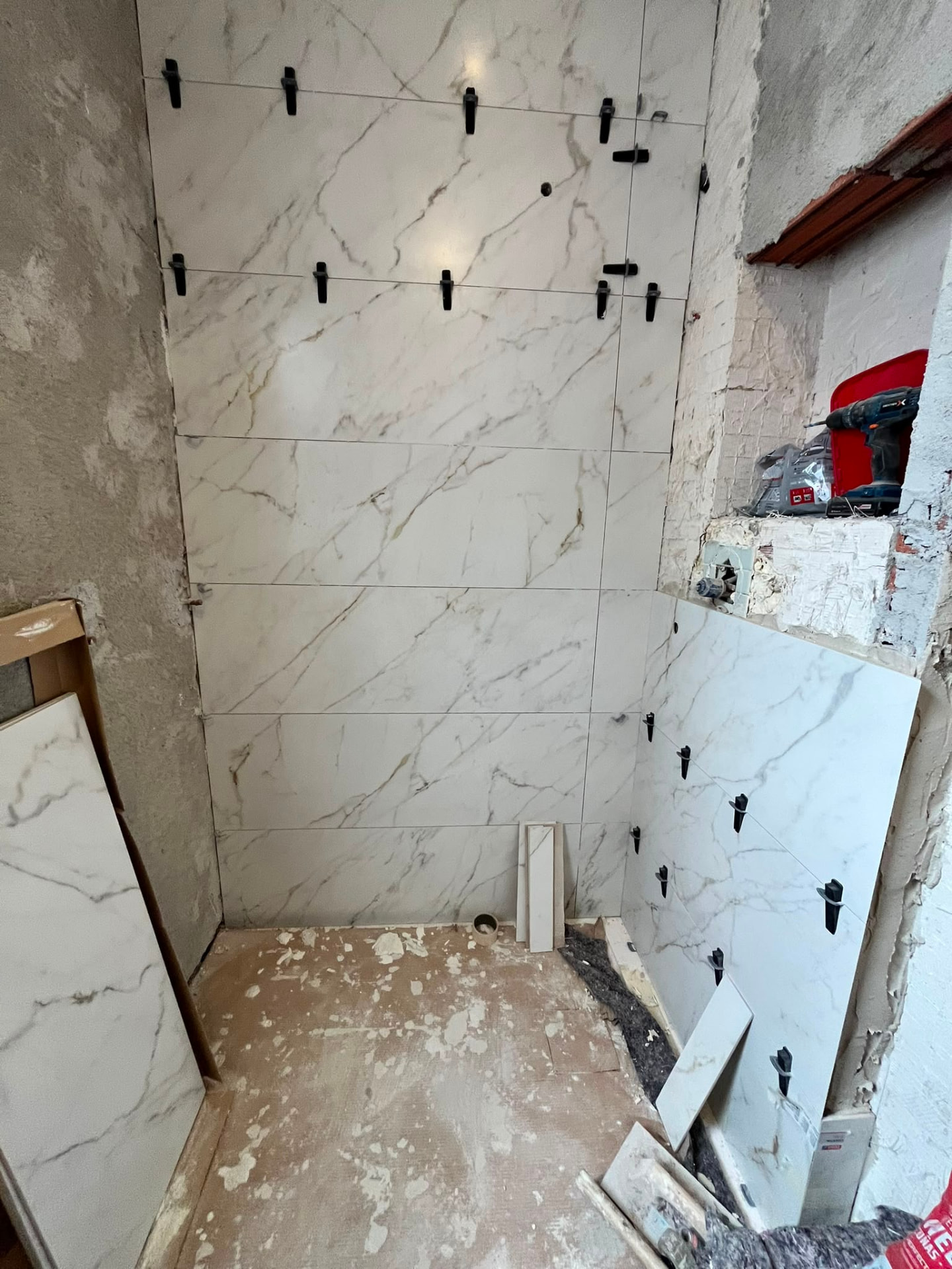 Avance del alicatado con crucetas de nivelación en reforma de baño en Valencia